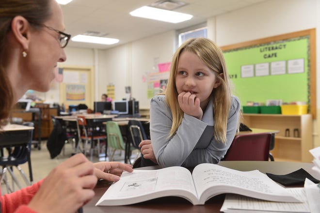 Heather Winfrey-Richman, a health educator for Methodist Medical Center’s Wellmobile, left, works with Hines Primary School third-grader Mikayla Crandell, 8, as part of the Peoria District 150 Reading Buddies program that pairs volunteers with students selected by the teachers to receive additional help.