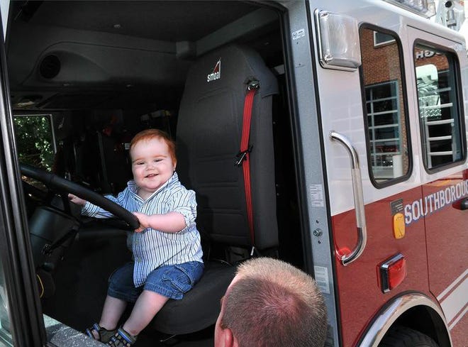 Southborough firefighter Chris Shanahan gets a smile out of his 18-month-old son, Brendan, at an August event. Brendan had been recently diagnosed with cancer.