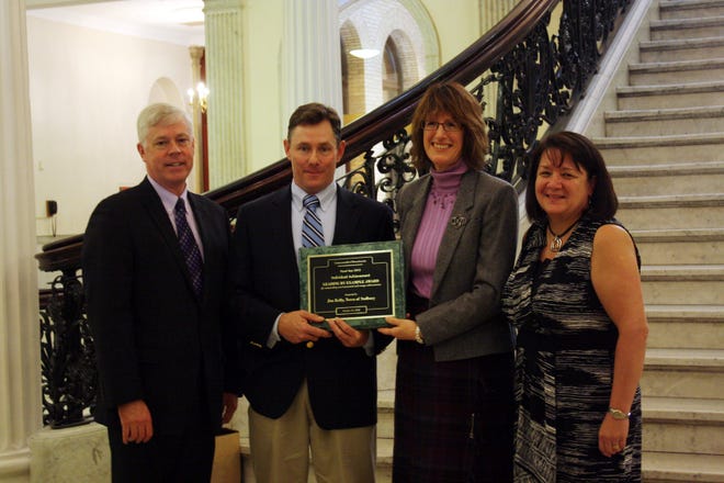 Sudbury Combined Facilities Director Jim Kelly poses at the State House with his 2012 "Leading by Example" award with, from left to right, Secretary Richard K. Sullivan Jr. of the state's Executive Office of Energy and Environmental Affairs; Meg Lusardi, director of the Department of Energy Resources' Green Communities Division; and Sudbury Town Manager Maureen Valente.