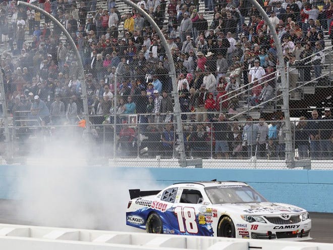 Driver Joey Logano does a burnout in front of the grandstands after winning the NASCAR Nationwide Series auto race at Phoenix International Raceway in Avondale, Ariz. Saturday, Nov. 10, 2012