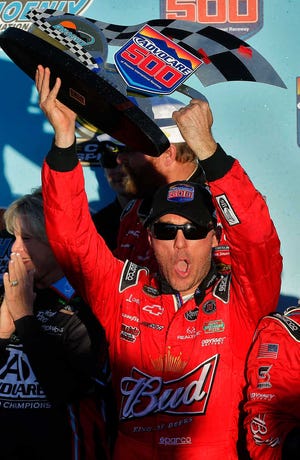 Kevin Harvick holds the trophy after winning the NASCAR Sprint Cup Series race on Sunday at Phoenix International Raceway in Avondale, Ariz.