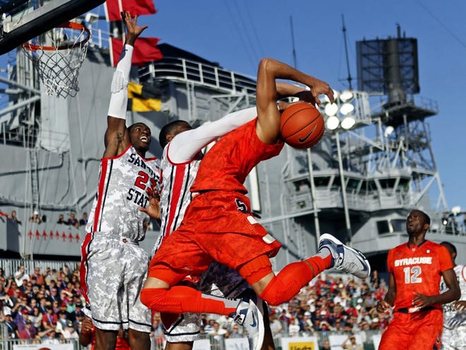 Syracuse's Michael Carter-Williams is fouled by San Diego State's Chase Tapley while driving to the basket during the second half of their NCAA college basketball game on the deck of the USS Midway in San Diego. Sunday, Nov. 11, 2012