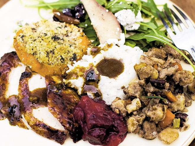 In this image taken on Oct. 8, 2012, a Thanksgiving dinner plate of cider brined turkey with sage gravy, peach cranberry sauce, sour cream and chive mashed potatoes, sausage pecan stuffing, arugula pear salad with pomegranate vinaigrette and goat cheese and herb crusted sweet potatoes is shown in Concord, N.H.