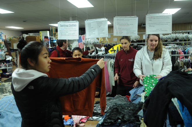 Players from Pudet Sound's volleyball team here for the NCAA tournament this weekend donate their time sorting close at the Community Action House Wednesday afternoon.