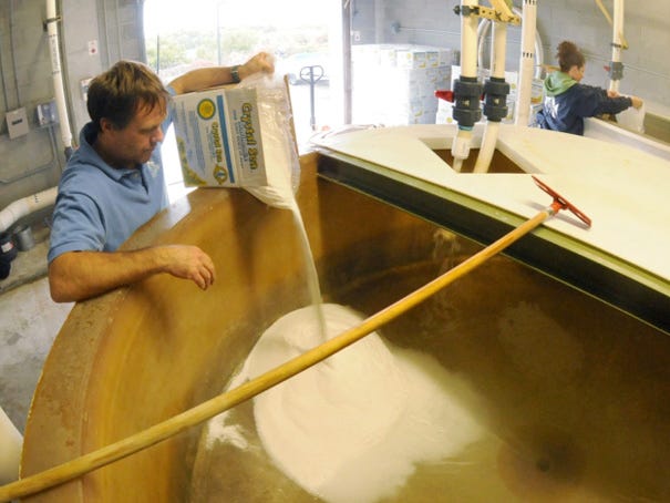 Aquarists Rich Bamberger and Shelly Anthony pour sea salt into mixing tanks on Nov. 15, 2012 at the North Carolina Aquarium at Fort Fisher. The NC Aquarium at Fort Fisher is looking at drilling a well to pump sea water into its exhibits.