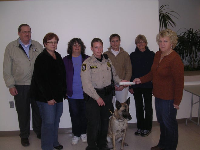 Allegan Sheriff's Deputy Kim Thorington poses K-9 "Lucky," surrounded by Holland Kennel members after the donation. Contributed