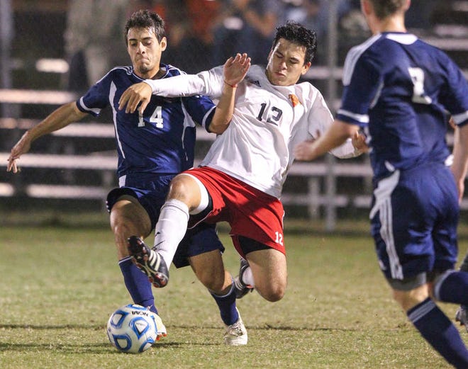 Flagler's Jean Vega (12) fights for the ball with Wingate's Fabio Azeredo Thursday during the first half of a NCAA Division II third-round game.