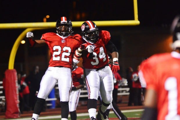 Chris Ingram (22) and Khalil Seaburn (34) jump high to celebrate another touchdown Friday against Jeannette.