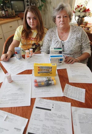 (Photo by Mike Hensdill/The Gaston Gazette) (L-R) Brittany Fralick (15) and her grandmother, Teresa Fralick pose in the kitchen of Teresa's home on A Street in Bessemer City Thursday afternoon, November 8, 2012 surrounded by forms and medication. Brittany had an ashma attack while attending Bessemer City High School and passed out.