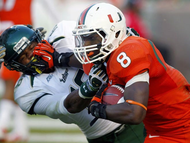 South Florida running back Marcus Shaw is tackled by Miami linebacker Gionni Paul (36) during the second half. Paul is a Kathleen High School graduate.
(WILFREDO LEE | THE ASSOCIATED PRESS)