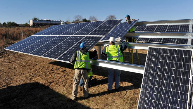 Interstate Electrical Services workers install a 900-kilowatt solar array with 3,100 solar panels on Washington Street parallel to Rte. 495 northbound, just before the Rte. 9 exit.