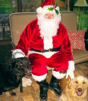 Santa Claws poses for a picture with some pooches