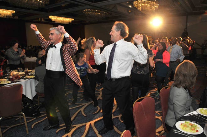 Steve Bisson/Savannah Morning News-Dale Holloway, left, and Greg Schroeder lead a group of dancers into the Victory Celebration at the Hyatt Regency Savannah.