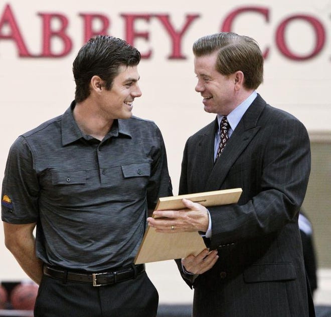 Belmont Abbey Athletic Director Stephen Miss presents golfer Adam Hedges with a plaque before the men's basketball game against Erskine on Saturday in the Wheeler Center at Belmont Abbey College. Hedges was recognized as an All-America Scholar and as a member of the All-America Golf Team.