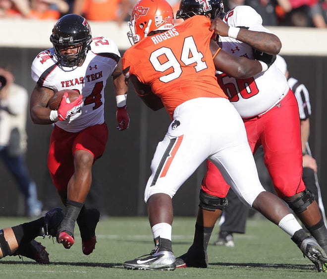 Texas Tech's Eric Stephens runs past Oklahoma State's Anthony Rogers during the Red Raiders' 59-21 loss to the Cowboys on Saturday in Stillwater, Okla.