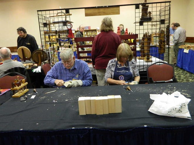 Carl Pilcher, of Valley Center, and Patsy Wilson, of Keller, Texas, take part in a woodcarving competition Sunday at the 33rd annual Kaw Valley Woodcarvers Association show at the Holiday Inn West Holidome, 605 S.W. Fairlawn.