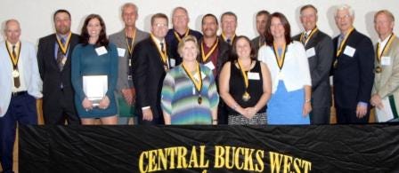 Central Bucks West Hall of Fame 2012 inductees include (front row, from left) Lynly Buchanan Sturza (representing Bill Buchanan) and Kathleen Corcoran. In the second row are Rebecca Jensen Nehibas (representing Steve Jensen), Ed Wild, Max Guydon and Karen Jensen (representing Steve Jensen). In back are Earl Huber, Dave Armstrong Jr., Paul Cichewicz, Jay Johnson, Tom York, Tim Sindorf, Jay Hoffman, Tom Ulrich and Tim Reiman.