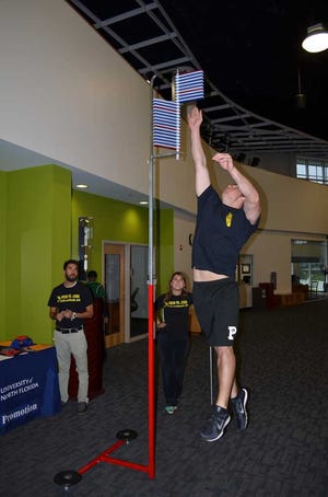 dan.scanlan@jacksonville.com--11/18/12 Staff watch as University of North Florida ROTC cadet Greg Talbert whacks aside 30 of the 49 rods on the vertical jump competition during Monday's Pros vs. Joes event at the three-month-old Student Wellness Complex.
