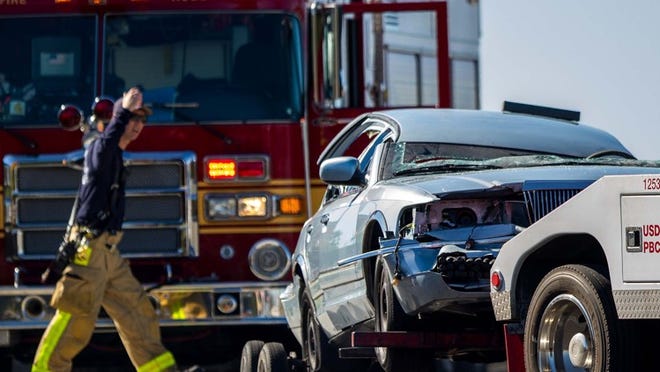 A car with a removed is moved by a tow truck following a three car accident on the Australian Avenue overpass that sent multiple victims to the hospital this morning, Monday, November 19, 2012. (Thomas Cordy/The Palm Beach Post)