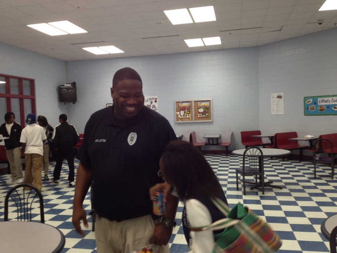 Jenel Few/Savannah Morning News Savannah High School resource officer John Cutter laughs with a student in the cafeteria.