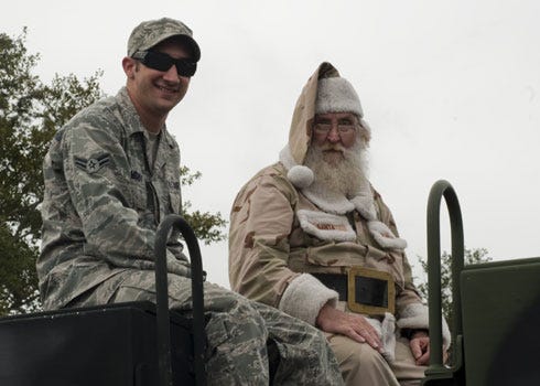 United States Air Force Airman 1st Class Zachary Lombardo, vehicle operations ap-prentice of 1st Special Operations Logistics Readiness Squadron sits with Santa Claus at the Veteran's Day Parade in Santa Rosa, Fla., Nov. 12, 2012. Military members par-ticipated in the Veteran's Day Parade to honor veterans of the present and past.