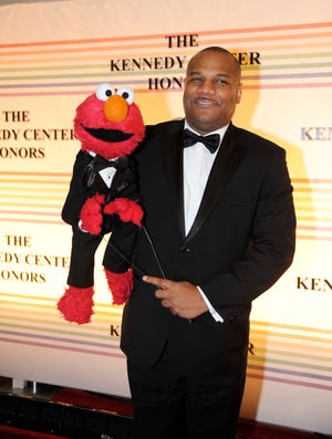 FILE - This Dec. 4, 2011 file photo shows "Sesame Street" character Elmo and puppeteer Kevin Clash arrive at the Kennedy Center for the Performing Arts for the Kennedy Center Honors gala performance in Washington. Clash has taken a leave of absence from the popular kids' show following allegations that he had a relationship with a 16-year-old boy. Sesame Workshop says Kevin Clash denies the charges, which were first made in June by the alleged partner, who by then was 23. In a statement issued Monday, Nov. 12, 2012, Sesame Workshop says its investigation found the allegation of underage conduct to be unsubstantiated. (AP Photo/Kevin Wolf, file)