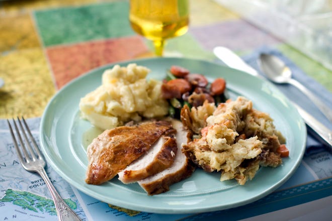 In this image taken on Oct. 2, 2012, a roasted plain Jane turkey and gravy, cheesy stuffing, buttery mashed potatoes, sweet and sour glazed carrots, and green beans are shown served on a plate in Concord, N.H. (AP Photo/Matthew Mead)