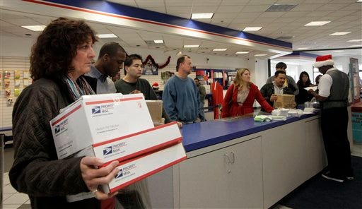 FILE - This Dec. 19, 2011 file photo shows people in line at the U.S. Postal Service Airport station in Los Angeles. Emboldened by rapid growth in e-commerce shipping, the cash-strapped U.S. Postal Service is moving aggressively this holiday season to start a premium service for the Internet shopper seeking the instant gratification of a store purchase: same-day package delivery. (AP Photo/Nick Ut, File)