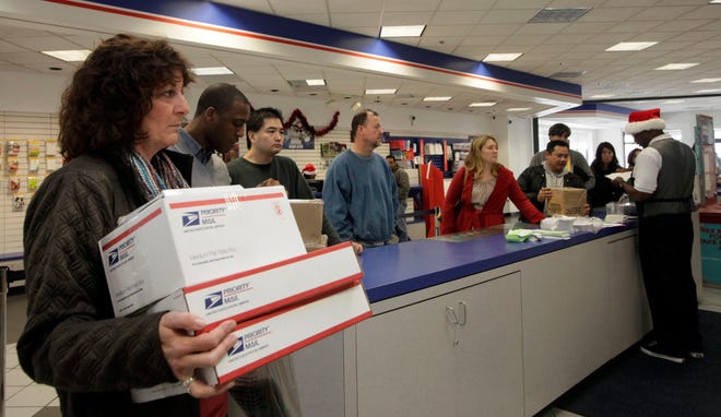This Dec. 19, 2011 file photo shows people in line at the U.S. Postal Service Airport station in Los Angeles. Emboldened by rapid growth in e-commerce shipping, the cash-strapped U.S. Postal Service is moving aggressively this holiday season to start a premium service for the Internet shopper seeking the instant gratification of a store purchase: same-day package delivery. (AP Photo/Nick Ut, File)