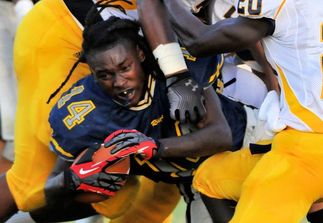 Ridge running back Shykeem Pitts charges through Winter Haven defenders after losing his helmet in Haines City. Friday, Aug. 24, 2012