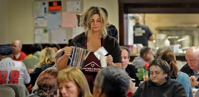 Volunteer Dina Ditullio of Duxbury serves juice and coffee during Thanksgiving dinner Thursday, Nov. 22, 2012, at Christ Episcopal Church in Quincy. The dinner was sponsored by Father Bill's homeless shelter.