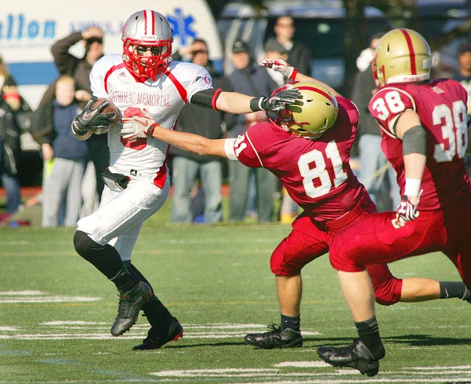 BC High Jonathan Lilley gets his hands on CM Kevin Bletzer who returns a punt. BC High hosted Catholic Memorial in the Thanksgiving Day football rivalry , Thursday, Nov. 22, 2012.