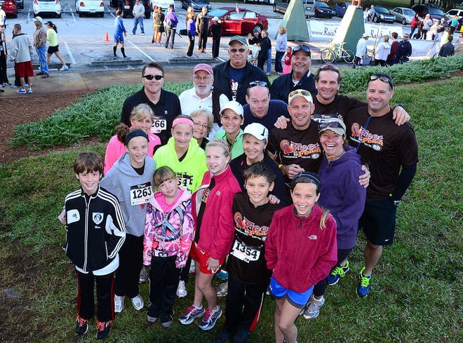 Twenty members of the Robertson Family gather before Palm Coast's annual Feet to Feast Thanksgiving 15K/5K race in Palm Coast on Thanksgiving morning. The 20 members of the family came from around country for the holiday and the race. By PETER WILLOTT, peter.willott@staugustine.com