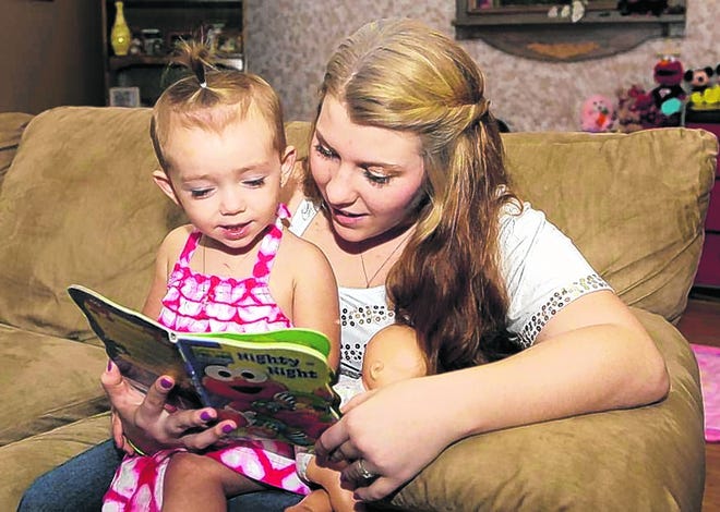 Kali Gonzalez reads to her daughter Kiah, 2, who was born when Kali was 15. 
Kali graduated from high school in May, but hers is a rare success story. AP 
PHOTO / JOHN RAOUX