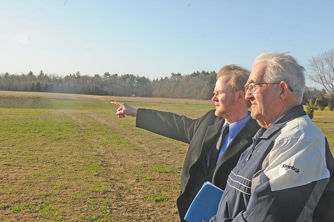 Berkley Selectmen George Miller, left, and Mark Pettey look over the land where the town will possibly be a solar farm.