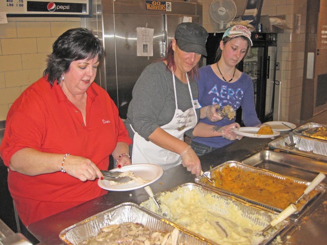 From left, Cheryl Corbett, of Medway, and Heidi and Lexi Souza, of Bellingham, serve up plates at the Corline Cronan’s Family Thanksgiving dinner at Coyle and Cassidy High School on Thursday, Nov. 22, 2012.