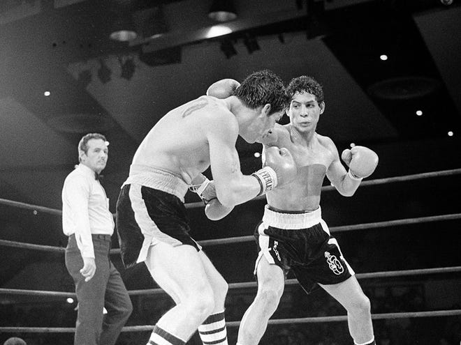 Luis Loy Jr., left, ducks under a blow by Hector Camacho early in a scheduled 10-round junior lightweight boxing bout at Felt Forum in New York in this July 11, 1982 file photo. Camacho died today after being taken off life support. He was 50.