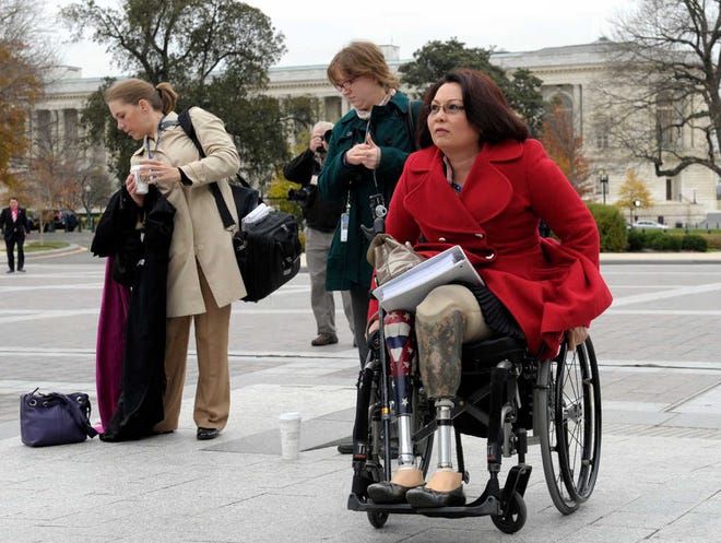 Iraq war veteran U.S. Rep.-elect Tammy Duckworth, D-Ill., who lost both legs in combat before turning to politics, arrives Nov. 15 for a group photo on the east steps of the Capitol in Washington.