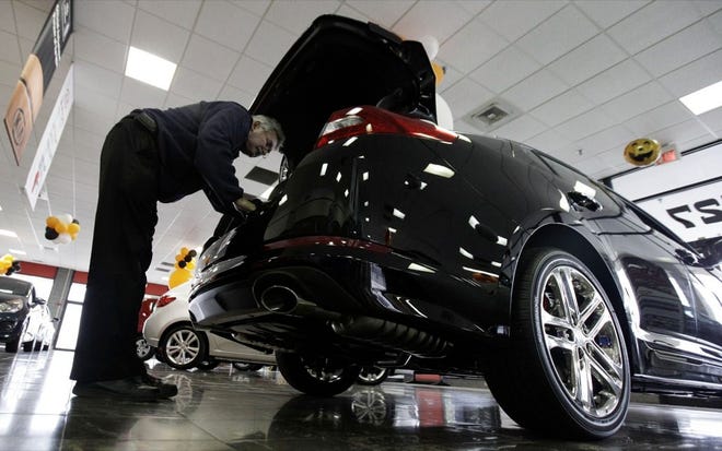 A CAR SHOPPER CHECKS OUT  a Kia Optima in Elmhurst, Ill., recently. The auto-finance industry is exploding with consumers looking to reap low rates. (NAM Y. HUH | THE ASSOCIATED PRESS)