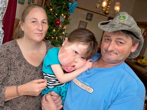 Angie and Danial Renfroe hold their daughter Katie at their home near Paxton. “We’ve never treated her like she has a handicap,” Angie says.