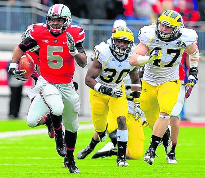 Ohio State quarterback Braxton Miller, left, breaks away from Michigan 
defenders Thomas Gordon, center, and Jake Ryan during the third quarter of 
the Buckeyes' 26-21 win over the Wolverines in Columbus, Ohio on Saturday. 
ASSOCIATED PRESS / JAY LAPRETE