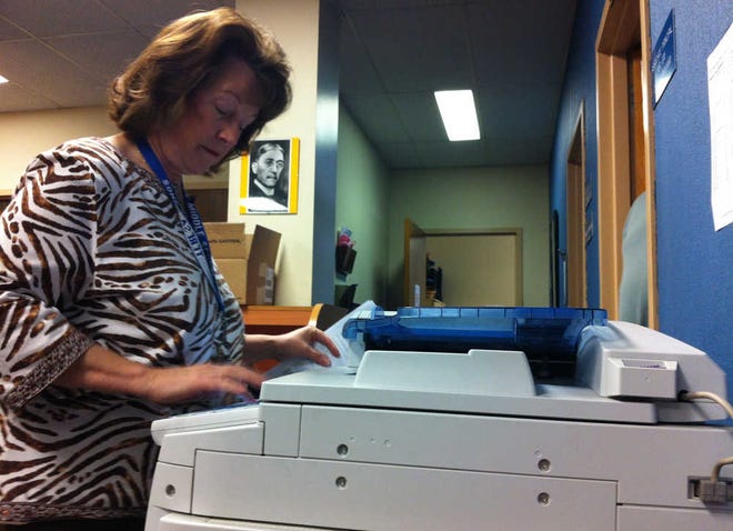 Teresa Songs, principal at Chase Middle School, scans documents to include in a new online evaluation system for teachers and principals.