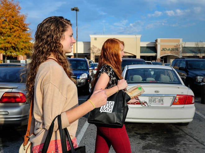 Sam Eberhard, left, and her sister Tiffany Eberhard use reusable bags to carry their groceries to their car in Athens, Ga., Friday, Nov. 23, 2012. (AJ Reynolds/Staff)