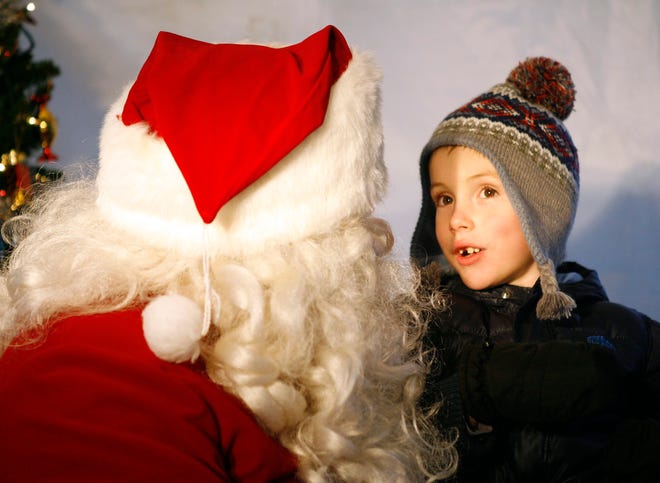 Eli Rasmussen, 6, of Rockford, tells Santa what he wants for Christmas Sunday, Nov. 25, 2012, during the Rockford Park District's annual lighting of the holiday tree at the Nicholas Conservatory and Gardens in Rockford.