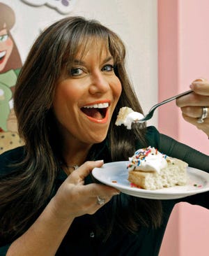 In this Oct. 11, 2012 photo, "Hungry Girl" Lisa Lillien poses in her office in the Woodland Hills area of Los Angeles. She never set out to become a controverisal food maven, telling people how to eat their cake and keep their weight down too. Lillien was just another LA "Hungry Girl," a 30-something woman who would diet off that extra 20 pounds and then put the weight back on. That was until the former studio publicist started coming up with low-cal recipes for some of those favored foods and emailing them around to friends. Ten years later, Lillien sits atop a Hungry Girl empire. ( AP Photo/Nick Ut)