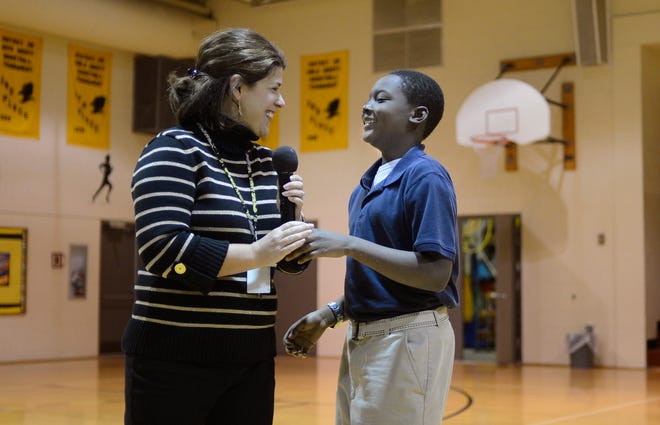 Terrius Winters, 11, laughs with Mark Bills Middle School Principal Laura Rogers on Monday at the school where Winters was recognized for saving a classmate who was choking on candy.