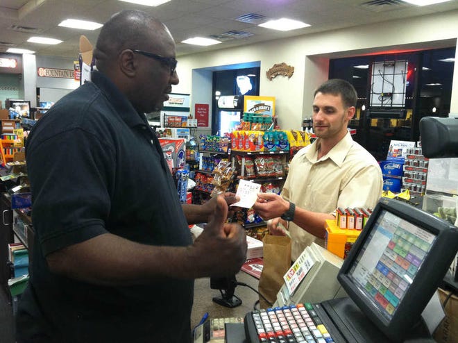 Dustin Tanner, right, buys a Powerball ticket at Carmelo's Marketplace on Tuesday evening. He plays regularly despite a bad record. 'I never win,' Tanner said. By SHELDON GARDNER, sheldon.gardner@staugustine.com