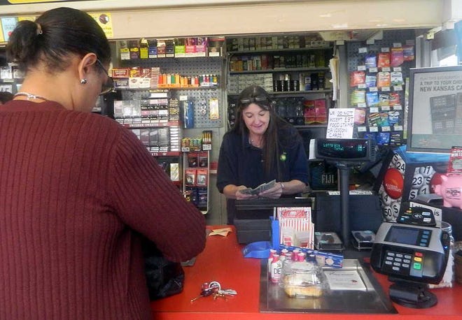 Regina Townsend, of Topeka, purchases a Powerball ticket Tuesday from Cindy Miller, an employee of the Downtown BP. The jackpot is at $500 million.