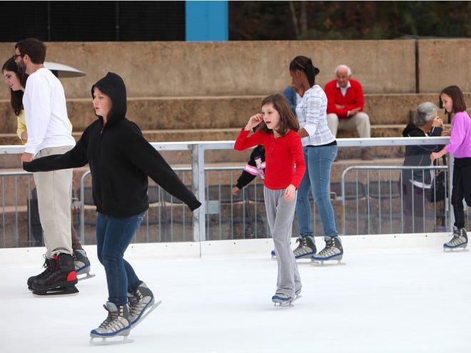 Skaters make their way around the ice skating rink next to the MIldred Westervelt Warner Transportation Museum in Tuscaloosa on Monday. The rink is part of a winter wonderland attraction called Holidays on the River that features carriage rides and appearances by Santa.