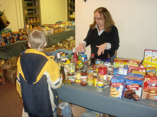 Belmont Food Pantry Director Patricia Mihelich talks to a member of Boy Scout Pack 96. The troop brought food to the Belmont Food Pantry on Nov. 18.